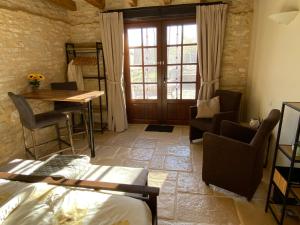 a room with a bed and a table and chairs at Domaine Rossignol Tournesol in Gourdon-en-quercy