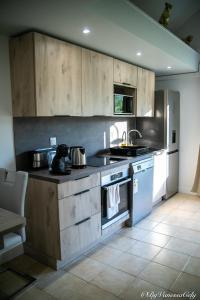 a kitchen with wooden cabinets and a stove top oven at Chez Clark et Elo in Bréançon