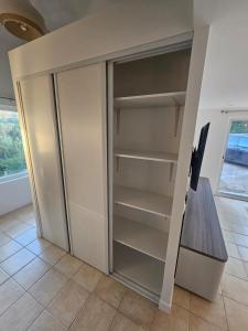 an empty refrigerator in a room with a table at Chez Clark et Elo in Bréançon +45 photos