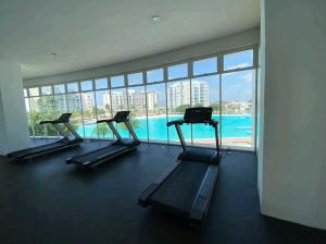 a gym with three treadmills and a swimming pool at Increible Apartment with beach Monterrey/Apodaca in Monterrey