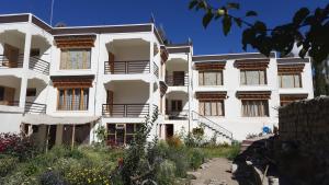 a white building with a garden in front of it at Nima's Villa in Leh