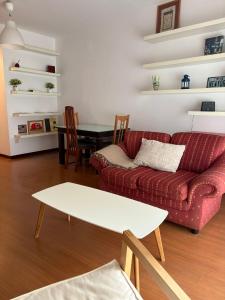 Una sala de estar con un sofá rojo y una mesa. en VUT A Casa da Herba, en Redondela