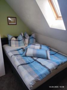 a bed with blue and white blankets and pillows at Ferienwohnung am Schloss in Stolberg i. Harz
