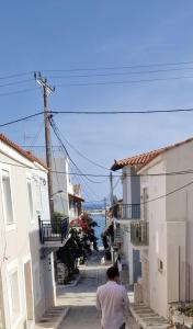 a man walking down a street between two buildings at Tipota - Charming house in Pythagoreio +9 photos