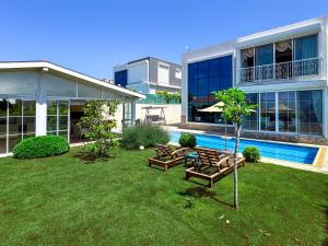 a house with a yard with benches and a pool at Villa Limon in Kusadası