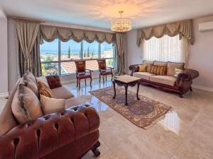 a living room with leather furniture and a large window at Villa Limon in Kuşadası