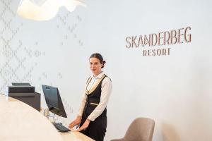 Una donna in piedi davanti a una scrivania con un computer di Hotel Skanderbeg a Golem Altre 37 foto