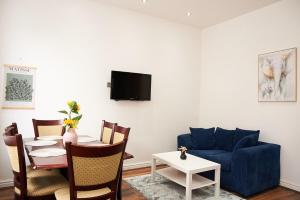 a living room with a blue couch and a table at West Yorkshire Stay - Heart of Leeds in Roundhay