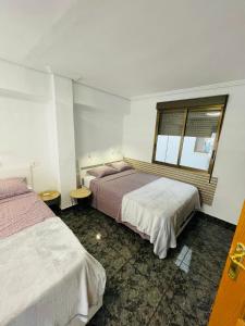 pokój hotelowy z dwoma łóżkami i oknem w obiekcie Playa Bonita Apartment w mieście Puerto de Sagunto
