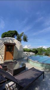 a yurt with a table and chairs next to a swimming pool at De Pointé Resort & Resto in Campaka