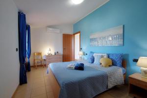 1 Schlafzimmer mit blauen Wänden und 1 Bett mit einer blauen Decke in der Unterkunft Casa "Maestrale " in Porto Pino