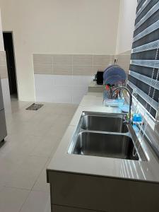 Un fregadero de cocina con un escurridor de platos al lado. en RB Homestay Modern Comfort, en Hutan Melintang 3 fotos más