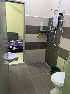1 cama y baño con ducha y aseo. en RB Homestay Modern Comfort, en Hutan Melintang