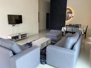 Una sala de estar con dos sofás y un televisor. en RB Homestay Modern Comfort, en Hutan Melintang