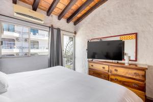 een slaapkamer met een bed, een tv en een raam bij Apartments Olas Altas Romantic Zone of Puerto Vallarta in Puerto Vallarta