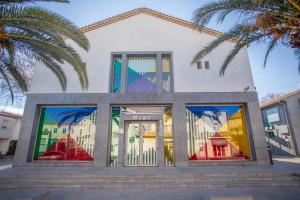 a building with windows and palm trees in front of it at SERIGNAN Vacances au soleil confort XXL in Sérignan