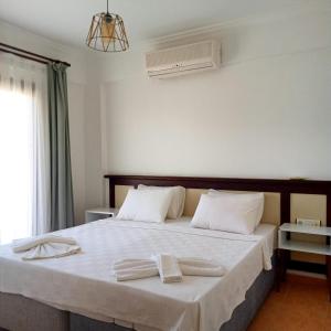 a bedroom with a bed with two towels on it at the mara süit otel in Yalıkavak