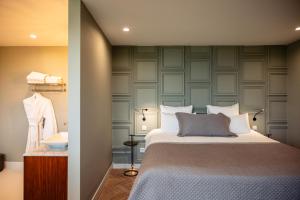 a bedroom with a bed and a wall at Boutique Hotel De Witte Dame in Abcoude