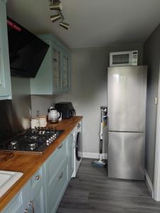 a kitchen with a stainless steel refrigerator and wooden counter tops at Beautiful fully renovated flat in Didcot in Didcot