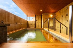 a large indoor pool in a room with wooden walls at BeppuOnsen Hotel Sansenkaku in Beppu