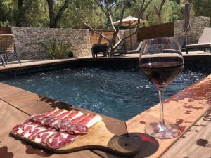 a glass of wine sitting next to a swimming pool at Hôtel E Tre Stelle in Bonifacio