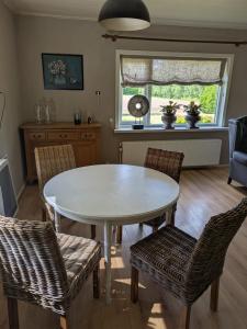a dining room with a white table and two chairs at Vakantiehuisje Wekerom in Wekerom