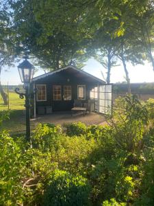 a small cabin with a bench and a lamp at Vakantiehuisje Wekerom in Wekerom