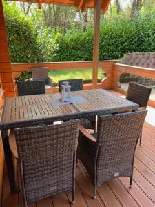 ein Tisch und Stühle auf einer Terrasse mit Sonnenschirm in der Unterkunft Ferienhaus Leonie, Holzhaus im Pfälzer Wald 76848 Hofstätten  + 3 Fotos