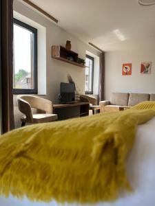 a hotel room with a yellow bed and a living room at Ferienwohnung Natur & Spa in Wiggensbach