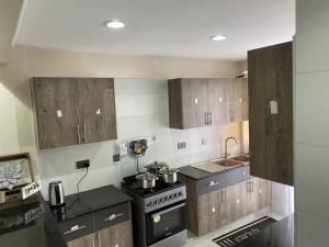 ナイロビにあるParkhust Staysの木製のキャビネットとコンロ付きオーブンを備えたキッチン +30枚の写真