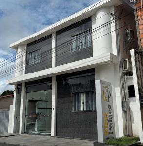 a white and black building with windows on it at Hotel King Palace - Hotel Irituia in Irituia
