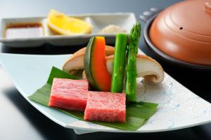 a plate of food with watermelon and vegetables on it at BeppuOnsen Hotel Sansenkaku in Beppu
