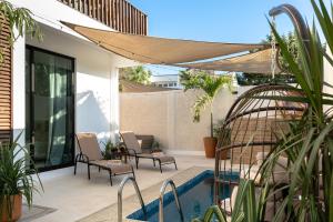 a patio with chairs and a swimming pool at Casa Eva -Ocean View Rooftop, Pool - La Punta in Puerto Escondido
