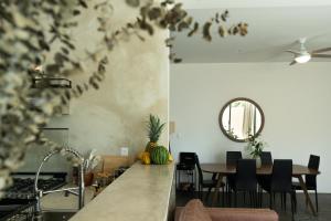 a kitchen and dining room with a table and a mirror at Casa Eva -Ocean View Rooftop, Pool - La Punta in Puerto Escondido