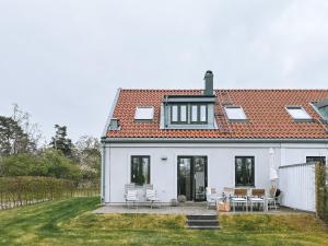 una casa bianca con tavolo e sedie di Boende med pool och tennisbana i familjevänligt område a Torekov