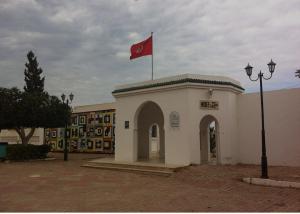 a building with a red flag on top of it at Chez leptis hedhoude vue mer in Lamţah