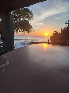 a sunset over the ocean with the sun setting at Hostal Pelican in El Gigante