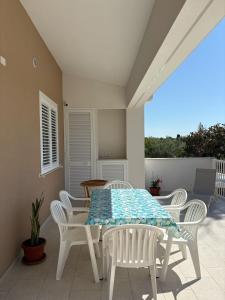 Una mesa blanca y sillas en un patio. en Casa Dei Gelsi, en Pozzallo