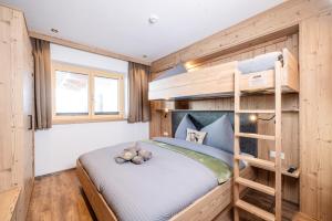 a bunk bed in a small room with a ladder at BEIM LOIS Dorfblick - AlpenLuxus Collection in Gerlos