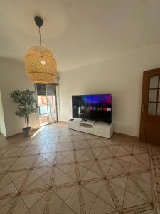 a living room with a flat screen tv and a potted plant at Elegant Getaway II - Lisbon- 2 bedroom apartment in Montijo in Atalaia +2 photos