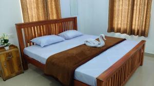 a bedroom with a bed with a swan on it at Blooms home stay in Thekkady