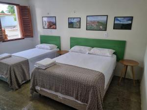 a bedroom with two beds and a table and a window at Casa Seu Quinca - Portalegre, RN Brasil in Portalegre +30 photos