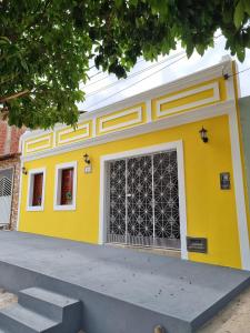 a yellow building with a large garage door at Casa Seu Quinca - Portalegre, RN Brasil in Portalegre