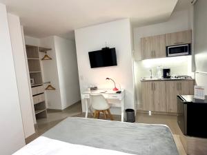 a small room with a bed and a desk at On Apartasuites in Cali