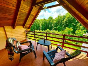 a screened in porch with chairs and a table at Foresta Home in Gradačac