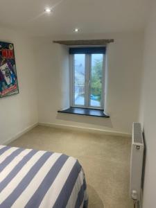 a bedroom with a bed and a window at Hideaway Cottage in Camelford