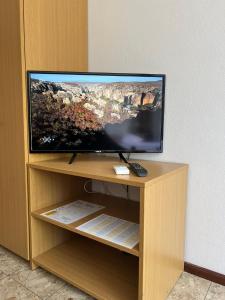 een flatscreen-tv bovenop een houten entertainmentcentrum bij Holiday Sun Accommodations in Orebić