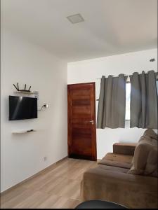 a bedroom with a bed and a tv on a wall at Aconchego Jardim Ipê proximo ao Paraguai in Foz do Iguaçu