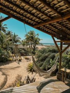 a hammock on a beach with the ocean at Casa Del Mar in Marau