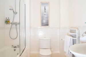 a bathroom with a shower and a toilet and a sink at Oakdale at Centrium in Woking +19 photos